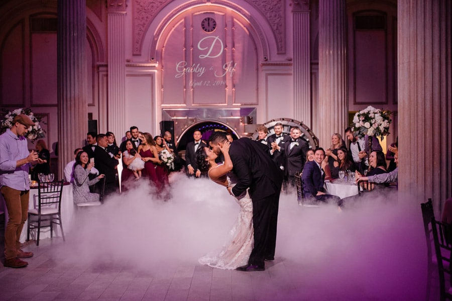 bride and groom kissing after first dance as fog fills the dance floor